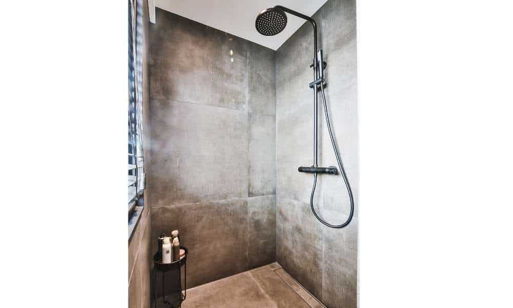 Why is it important to clean shower tiles without scrubbing?